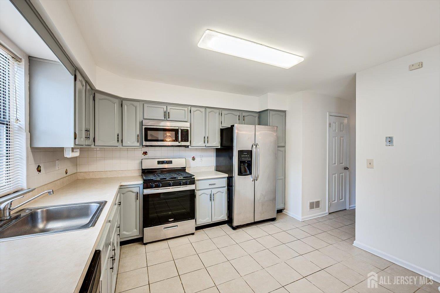 404 Maplecrest Road Edison, NJ 08820 - Photo 12 of 25 a kitchen with stainless steel appliances a refrigerator sink and stove