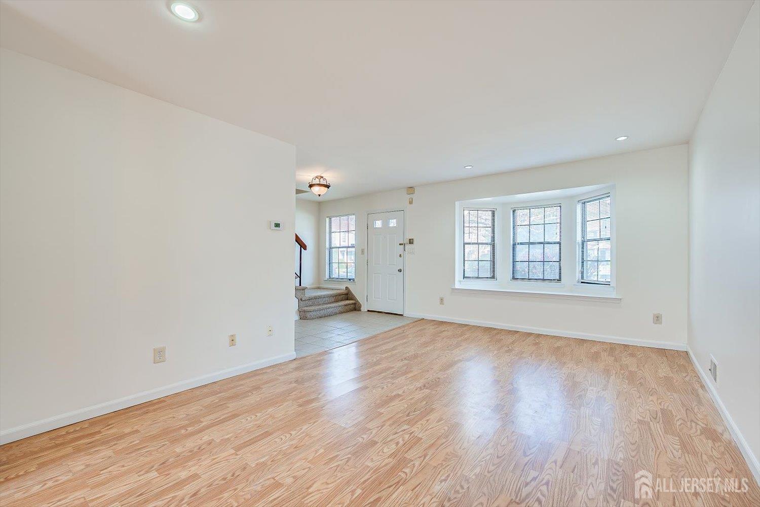 404 Maplecrest Road Edison, NJ 08820 - Photo 7 of 25 an empty room with wooden floor and windows