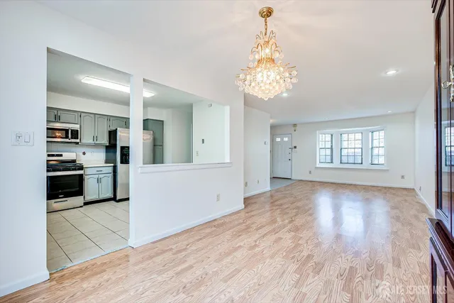 a view of a kitchen with a sink and dishwasher a refrigerator with wooden floor