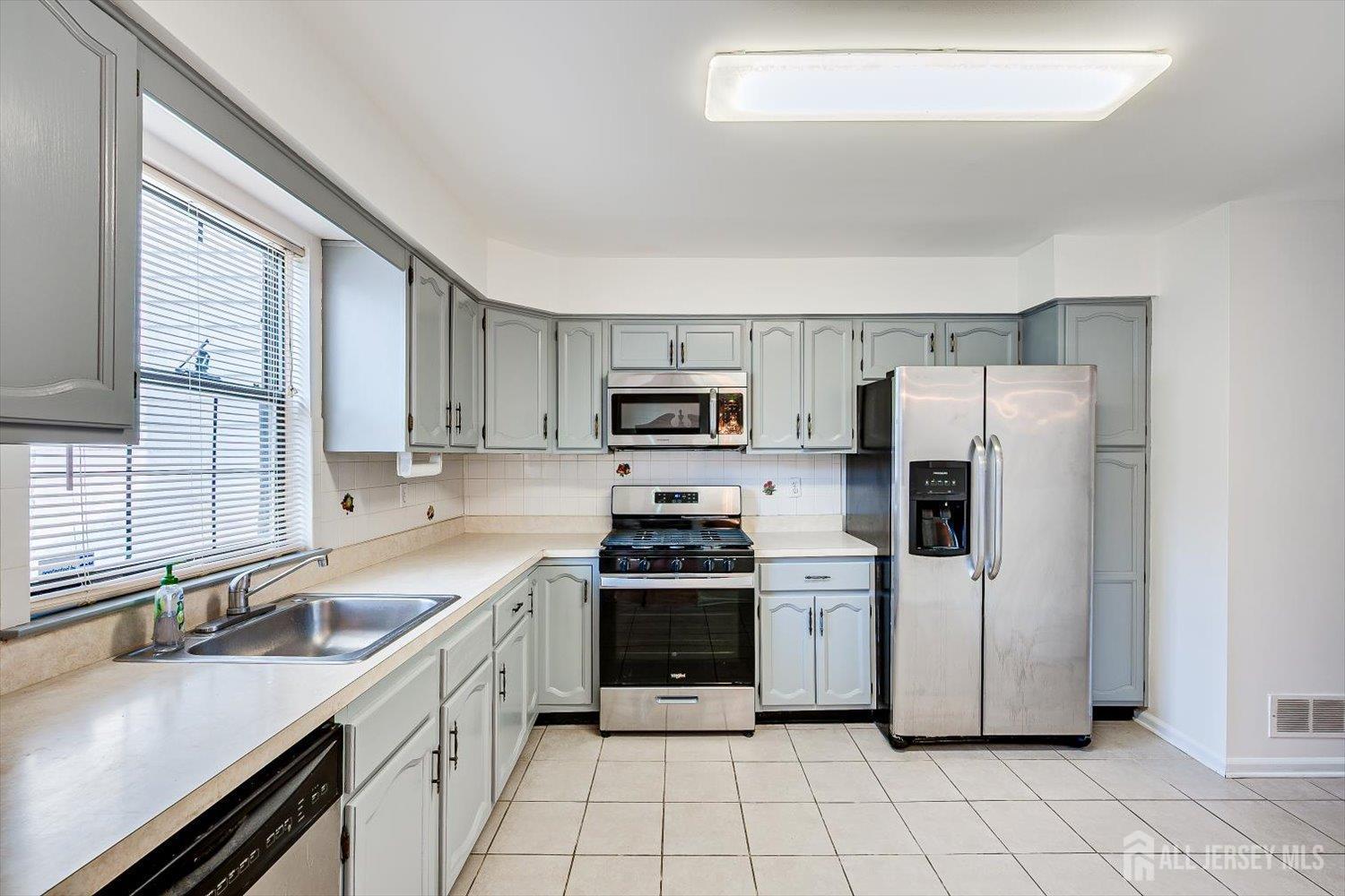 404 Maplecrest Road Edison, NJ 08820 - Photo 10 of 25 a kitchen with a sink white cabinets and stainless steel appliances