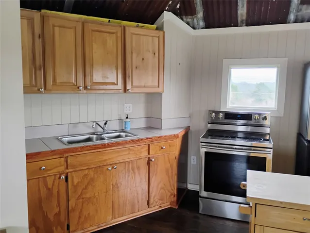 a kitchen with stainless steel appliances granite countertop a sink stove and cabinets