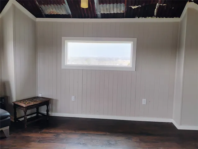 a view of a room with wooden floor and a window