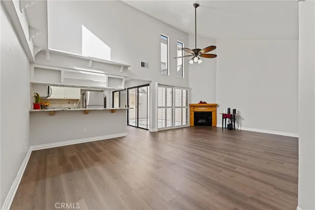 a view of empty room with wooden floor and ceiling fan