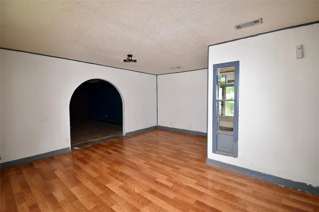 a view of empty room with wooden floor