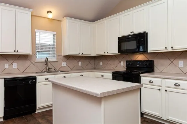 a kitchen with cabinets appliances a sink and a counter
