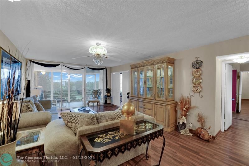 Palm Aire Pompano Beach, FL 33069 - Photo 4 of 12 a living room with furniture a large window and a chandelier