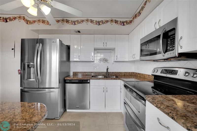 Palm Aire Pompano Beach, FL 33069 - Photo 6 of 12 a kitchen with stainless steel appliances granite countertop a sink stove and refrigerator