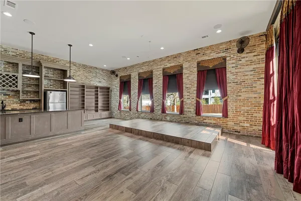 a view of a patio with table and chairs and couches with wooden floor and fence