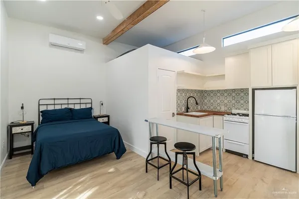 a bedroom with a bed and a refrigerator