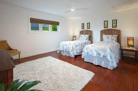a bedroom with two beds and painting on the wall