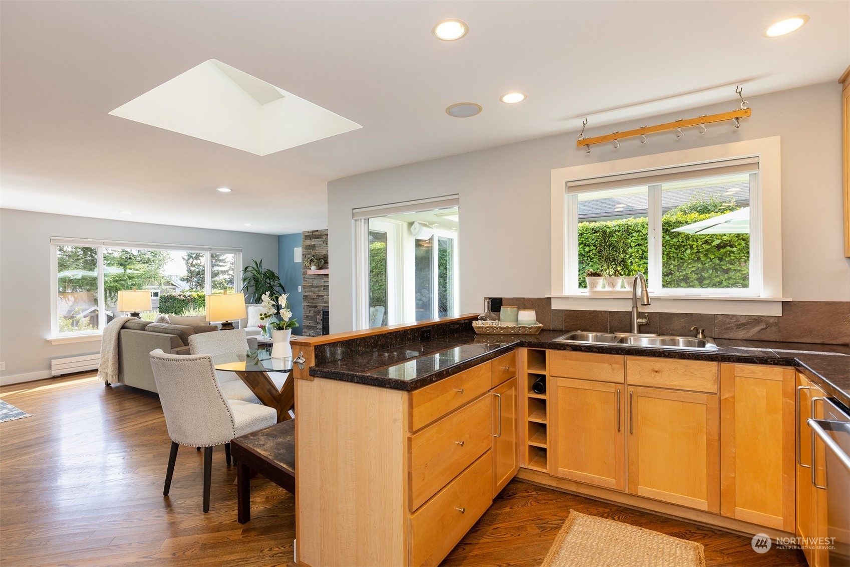 1505 35th Avenue South Seattle, WA 98144 - Photo 12 of 39 a kitchen with granite countertop a sink and white cabinets with wooden floor