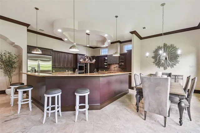 a dining room with furniture large windows and a chandelier