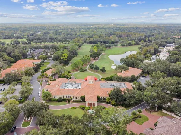 a view of a house with large trees and plants