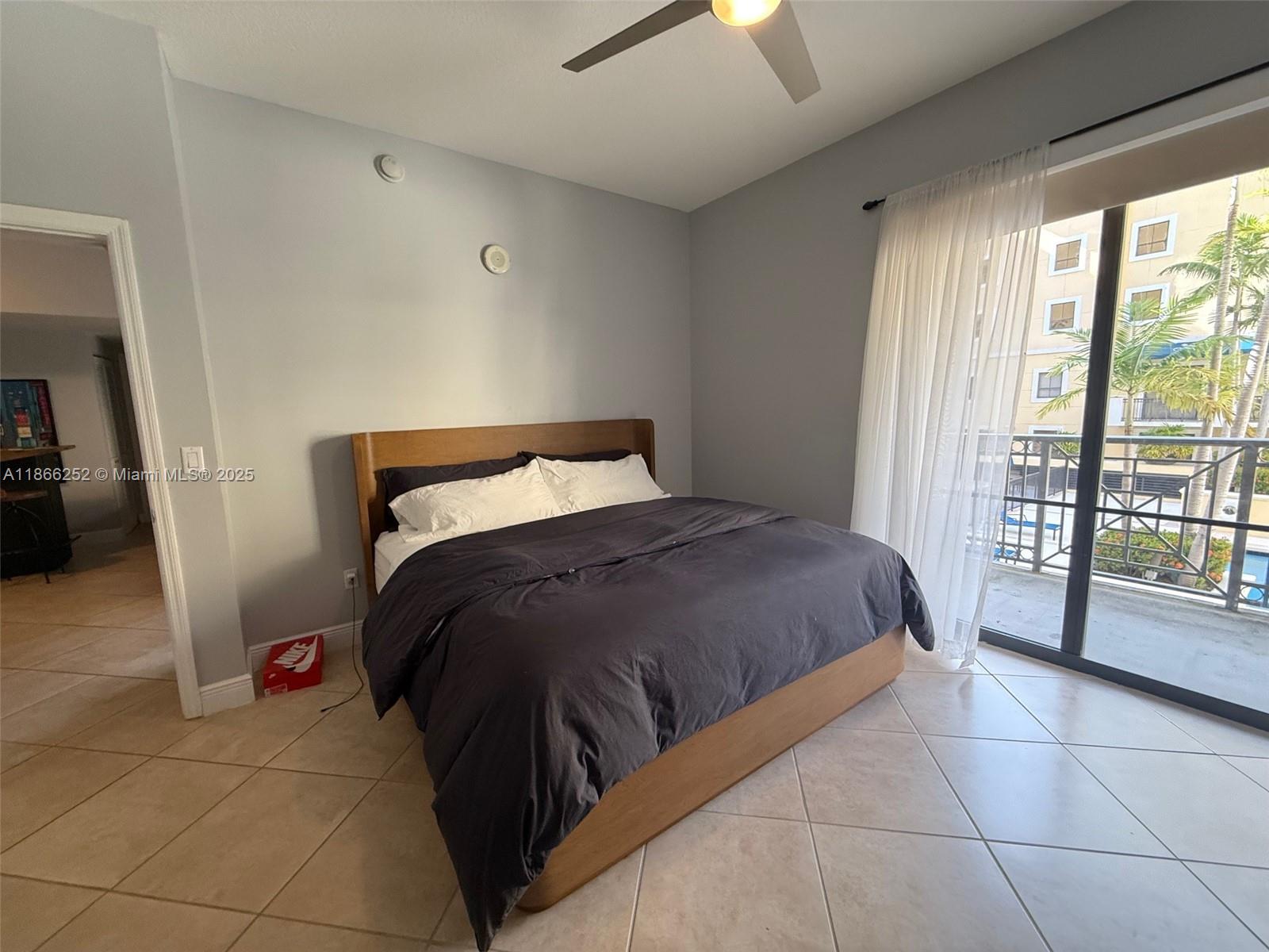 8395 Southwest 73rd Avenue, Unit 509 Miami, FL 33143 - Photo 16 of 41 a bedroom with a bed and glass door