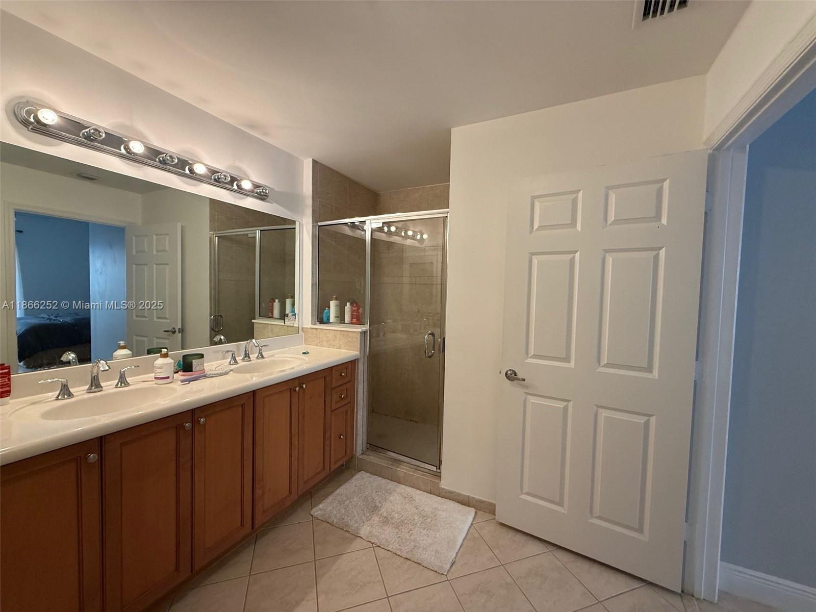 8395 Southwest 73rd Avenue, Unit 509 Miami, FL 33143 - Photo 17 of 41 a bathroom with a double vanity sink and mirror