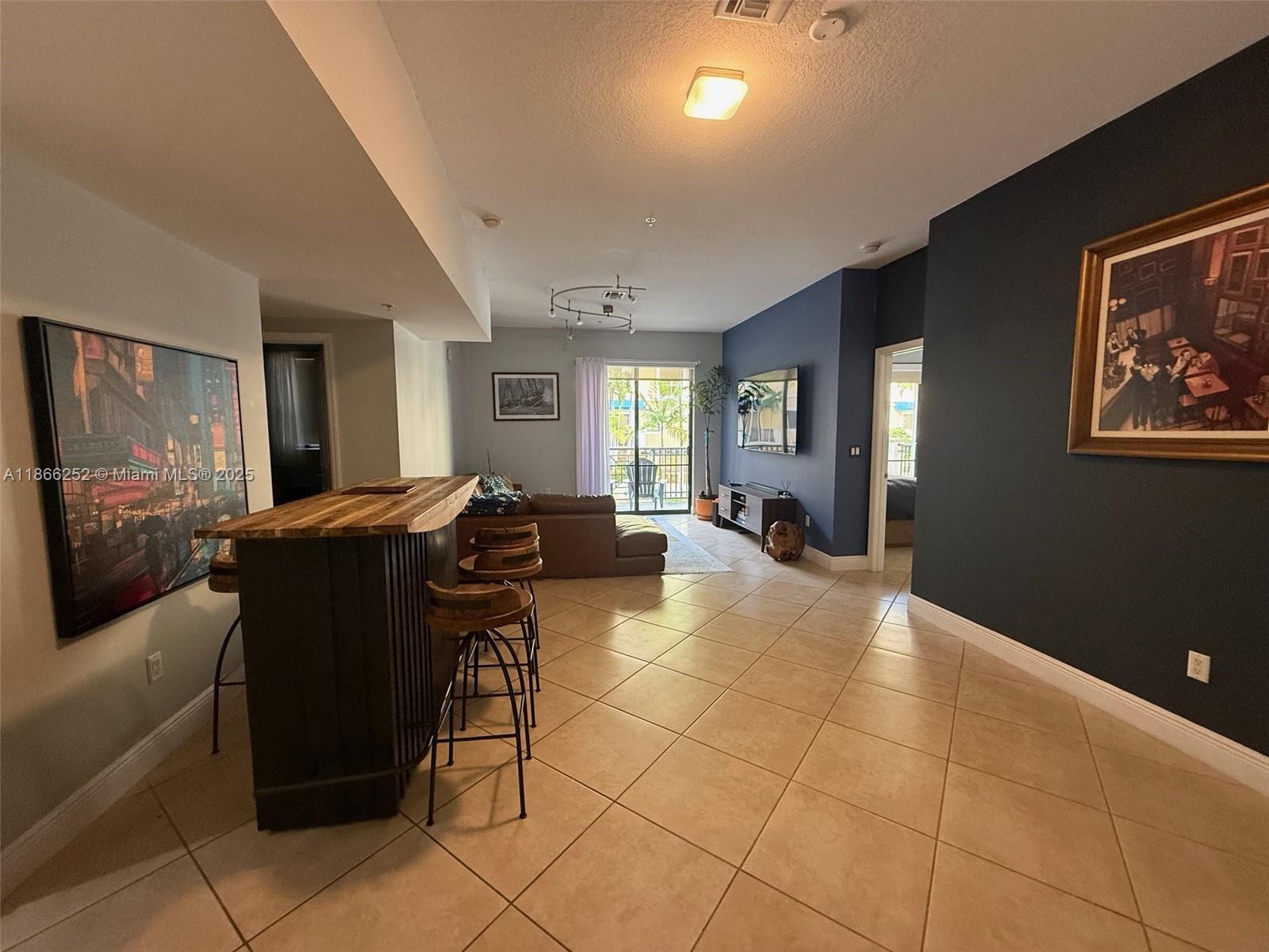 8395 Southwest 73rd Avenue, Unit 509 Miami, FL 33143 - Photo 3 of 41 a living room with furniture and a flat screen tv
