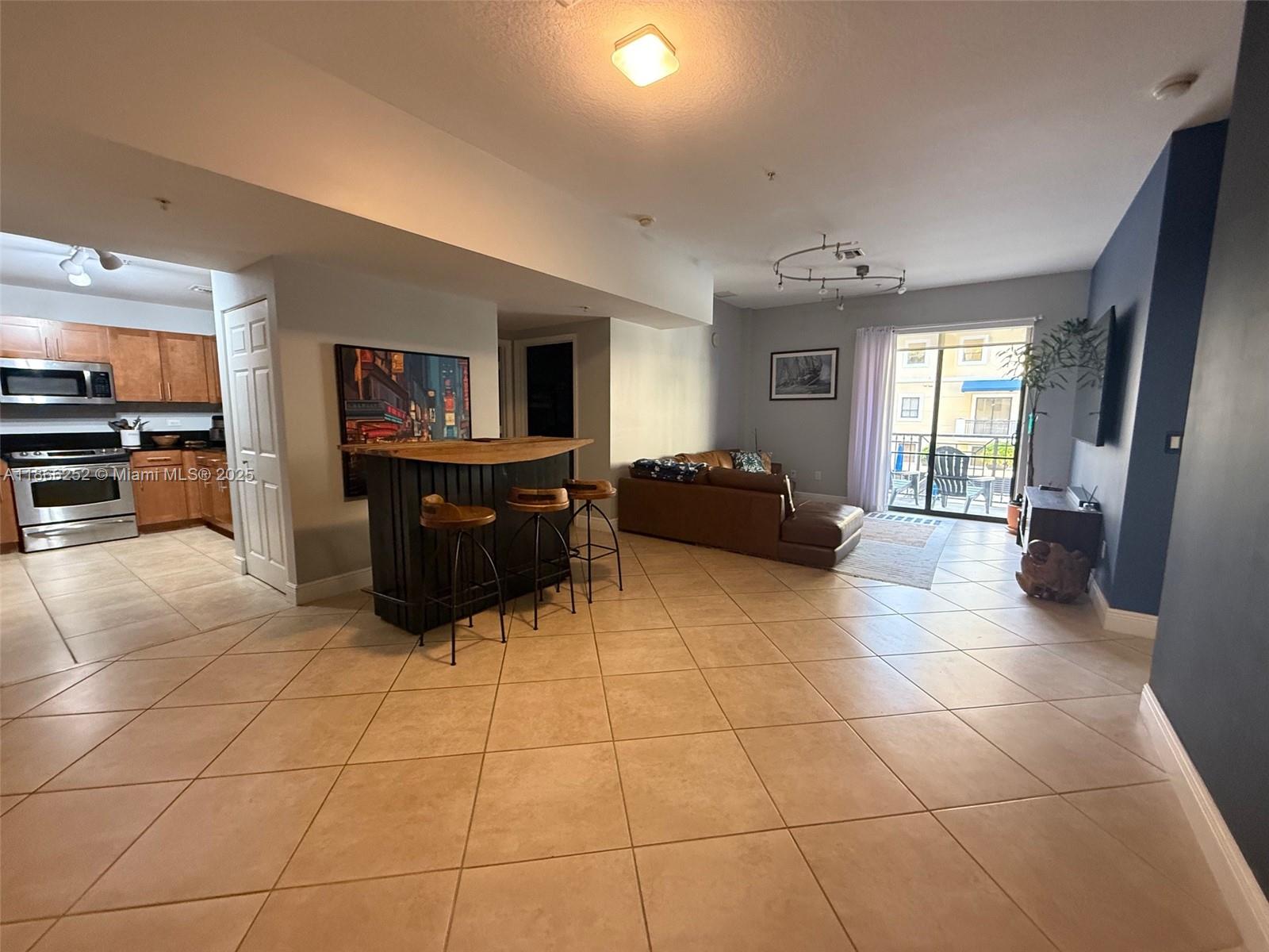 8395 Southwest 73rd Avenue, Unit 509 Miami, FL 33143 - Photo 4 of 41 a living room with furniture and a flat screen tv