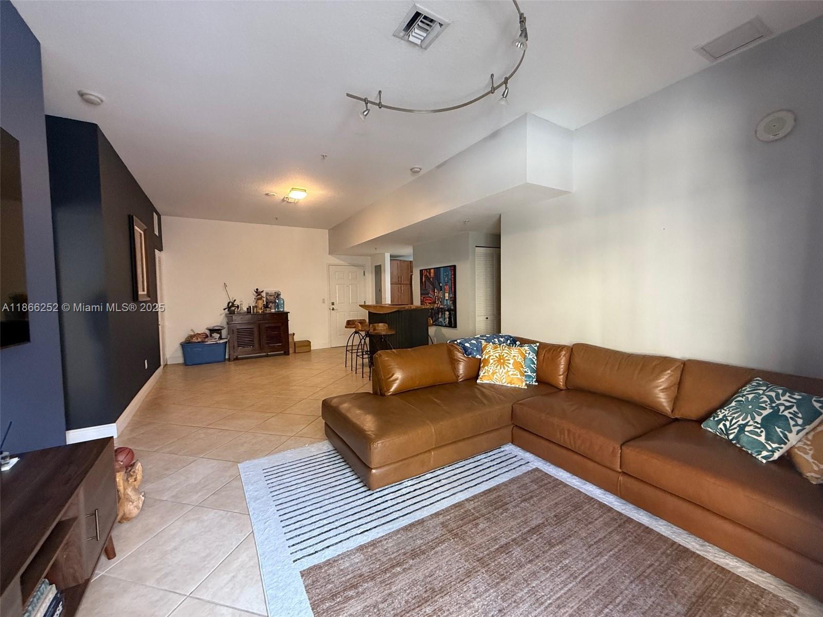 8395 Southwest 73rd Avenue, Unit 509 Miami, FL 33143 - Photo 5 of 41 a living room with furniture and a chandelier