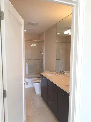 a bathroom with a granite countertop sink a toilet and shower