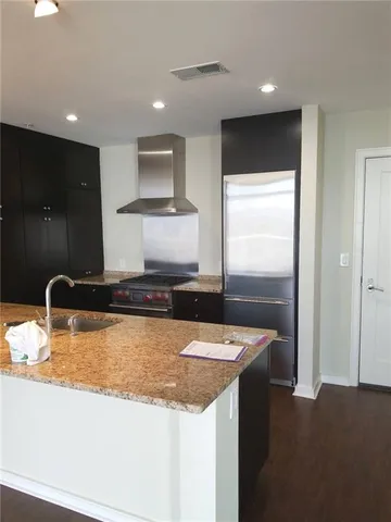 a kitchen with stainless steel appliances granite countertop a sink and a refrigerator