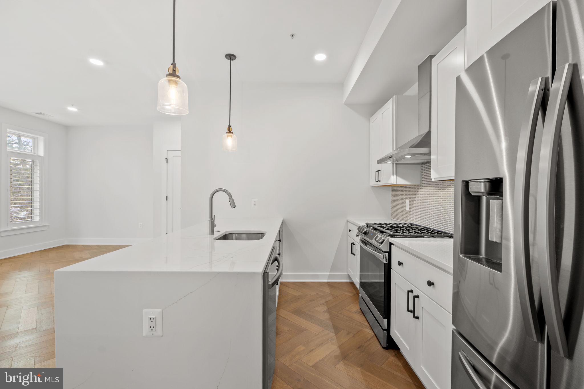 4315 Harrison Street Northwest, Unit 5 Washington, DC 20015 - Photo 11 of 33 a kitchen with stainless steel appliances granite countertop a sink a stove and a refrigerator