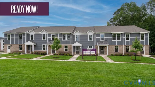 a front view of a building with a garden and trees