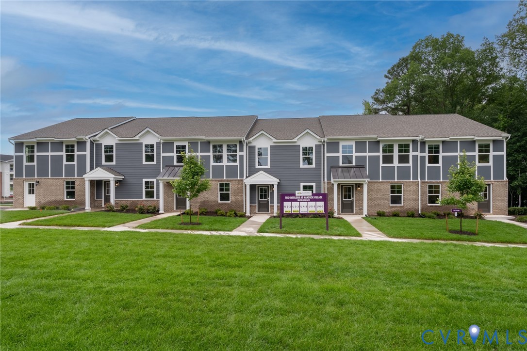 a front view of a house with a yard and trees