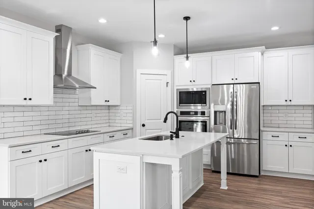 a kitchen with kitchen island a sink stainless steel appliances and cabinets