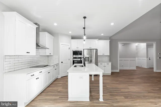 a large kitchen with stainless steel appliances kitchen island granite countertop a stove a sink and a refrigerator