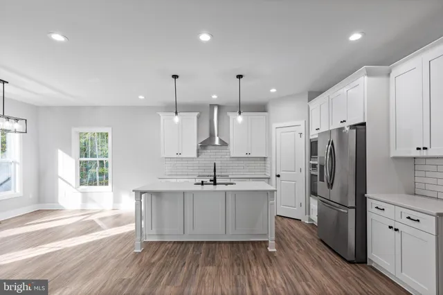 a kitchen with stainless steel appliances a sink cabinets and wooden floor