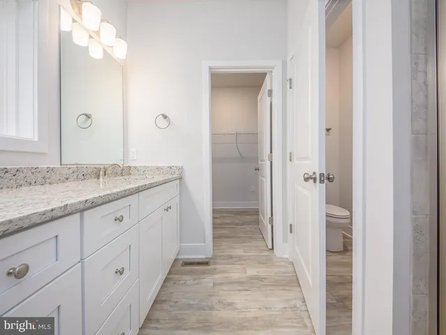 a spacious bathroom with a granite countertop sink mirror and a shower