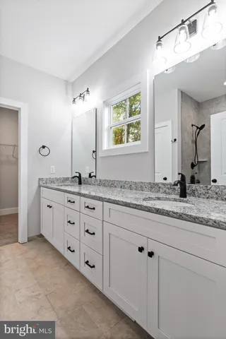 a bathroom with a granite countertop sink mirror and