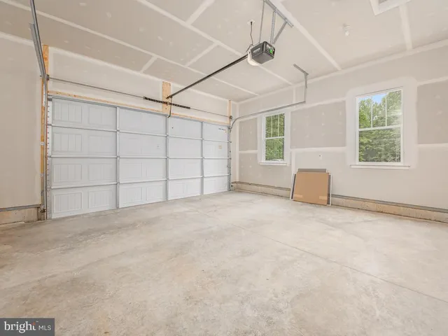 an empty room with windows and chandelier fan