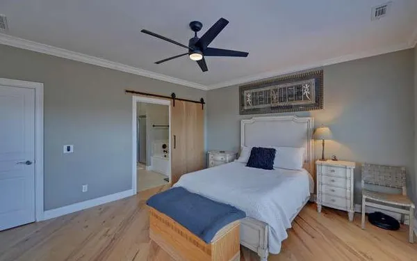 a bedroom with a large bed a chandelier and a closet