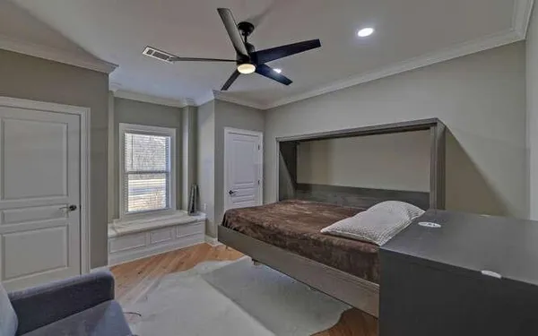 a bedroom with a large bed and a ceiling fan