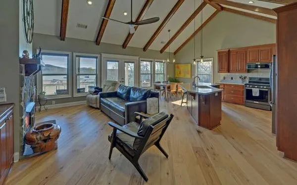 a living room with furniture a wooden floor and a large window