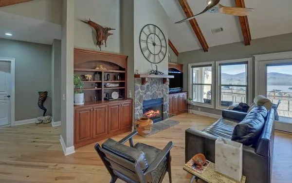 a living room with fireplace furniture and a large window