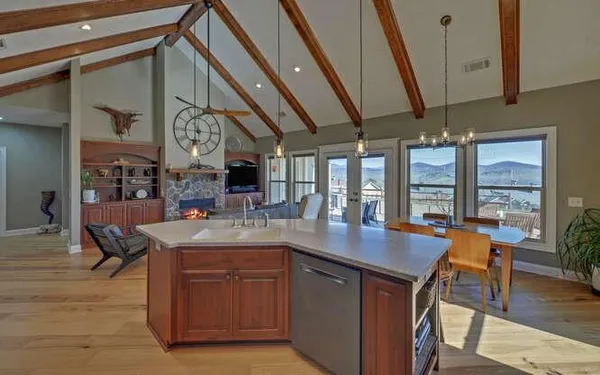 a kitchen with stainless steel appliances granite countertop a sink a counter space and a view of living room
