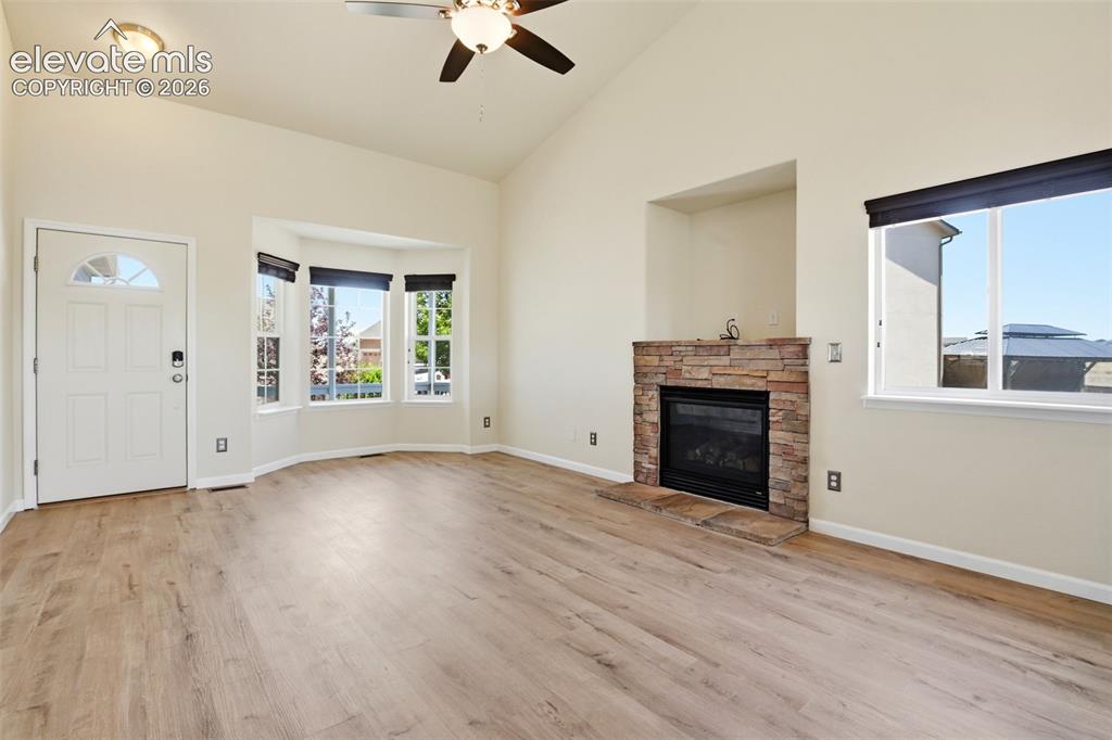 7806 Dutch Loop Colorado Springs, CO 80925 - Photo 5 of 41 an empty room with windows and fireplace