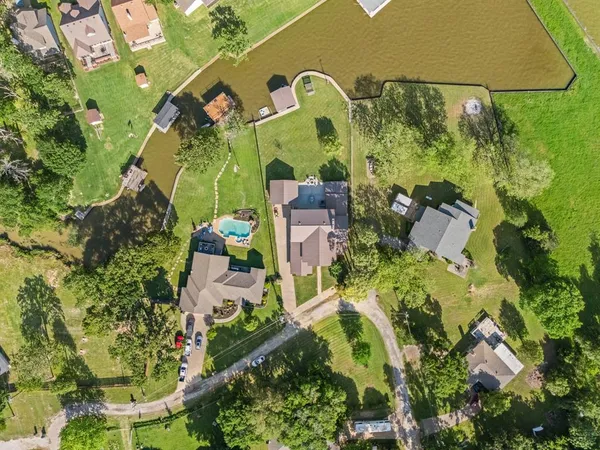 an aerial view of a house with a yard and lake view