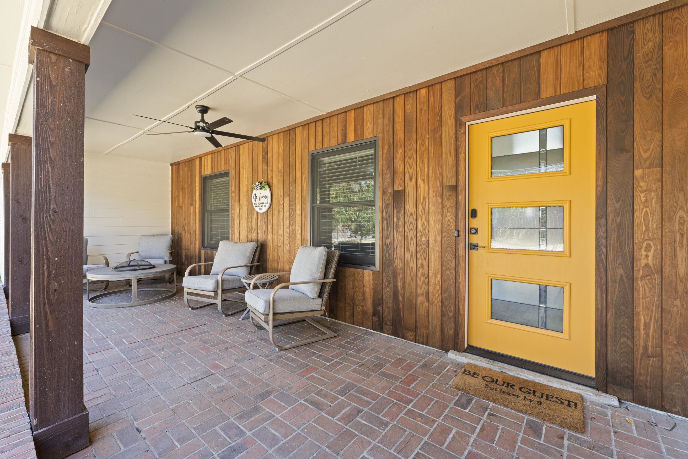 260 South Fenwick Road Memphis, TN 38111 - Photo 3 of 40 Charming covered porch with warm wood siding, a bold yellow door, and inviting seating- perfect for relaxing outdoors!