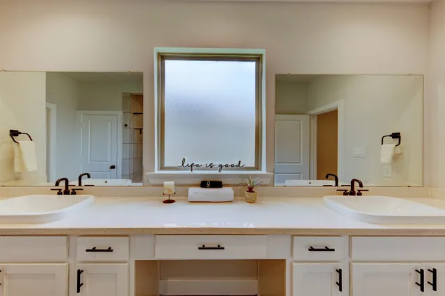 a bathroom with double vanity sinks and a mirror