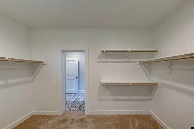 a view of walk in closet with empty racks