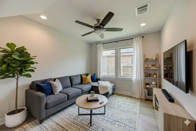 a living room with furniture a window and a flat screen tv