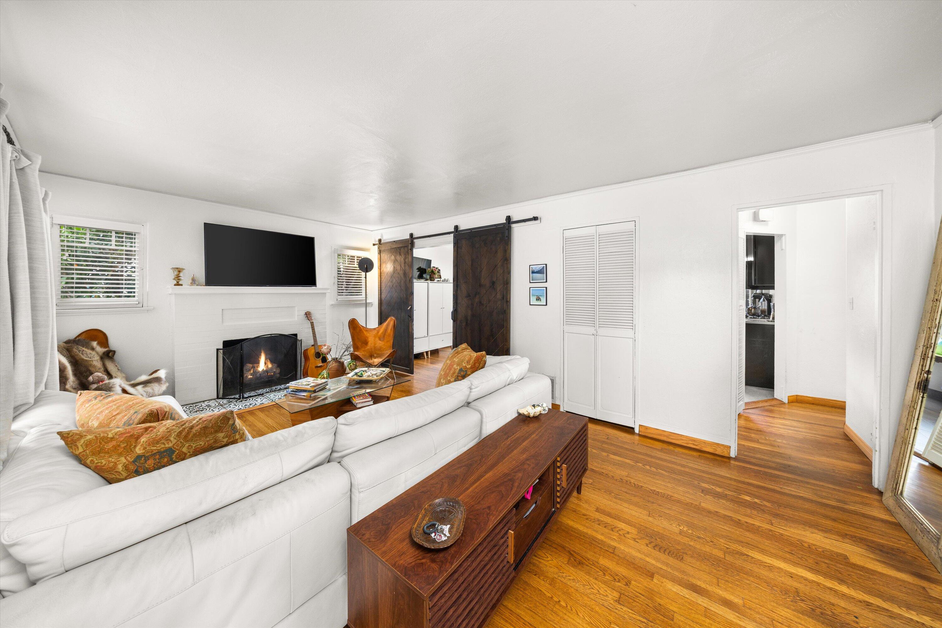 424 East Arrellaga Street Santa Barbara, CA 93101 - Photo 5 of 32 a living room with furniture flat screen tv and a fireplace