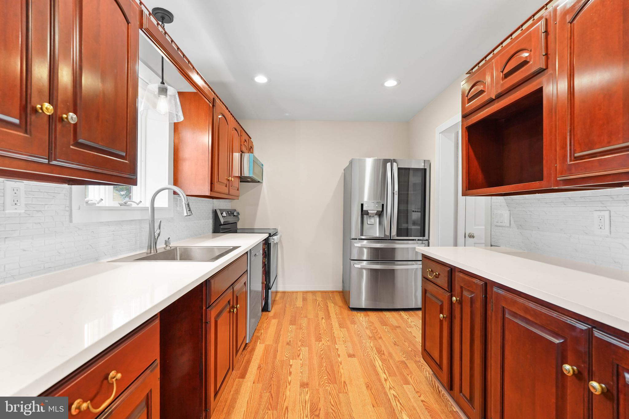 1600 Oaklawn Court Silver Spring, MD 20903 - Photo 20 of 62 a kitchen with stainless steel appliances granite countertop a sink and dishwasher a stove top oven with wooden floor