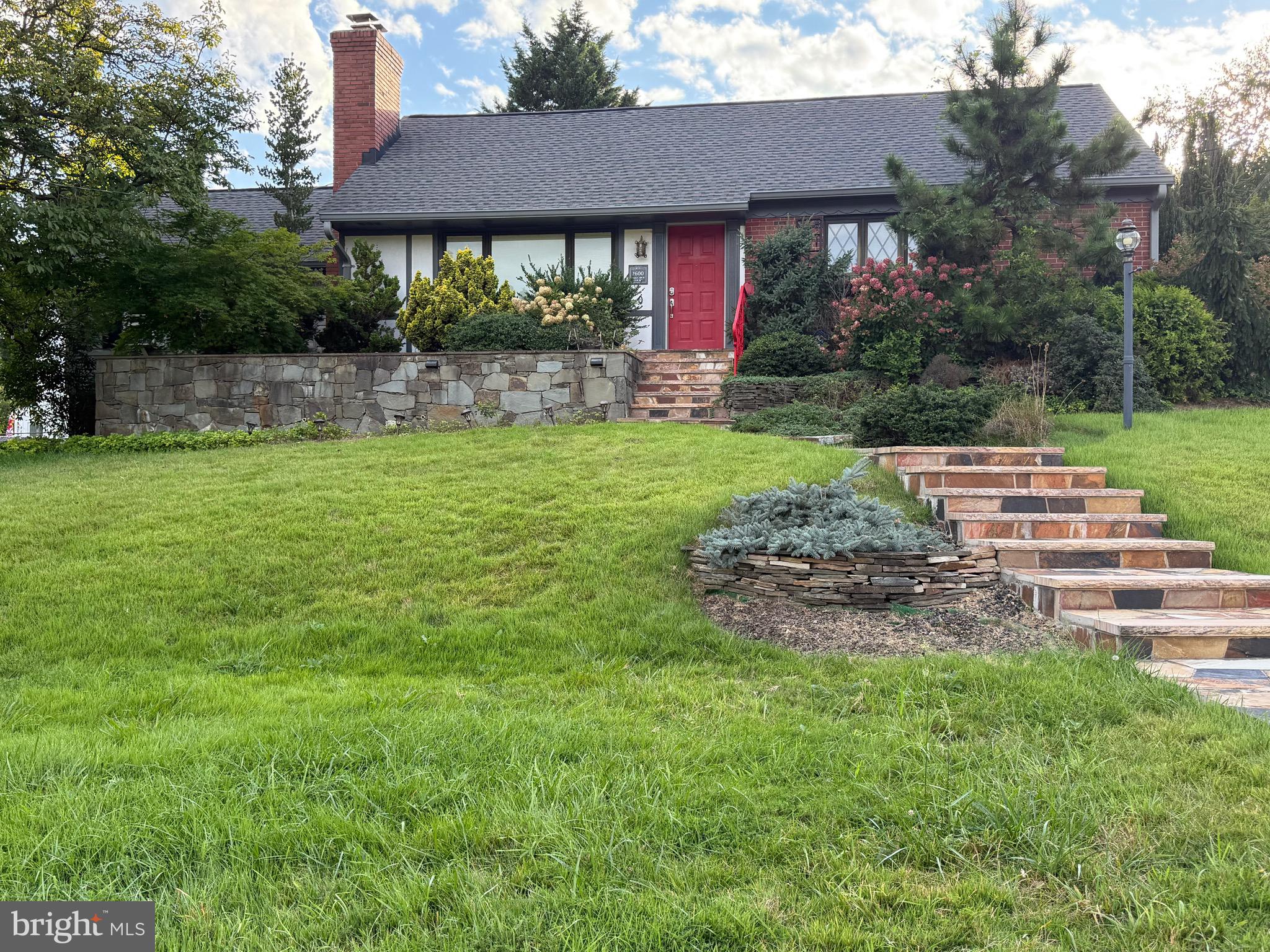 1600 Oaklawn Court Silver Spring, MD 20903 - Photo 4 of 62 a view of a house with a yard and table and chairs under an umbrella
