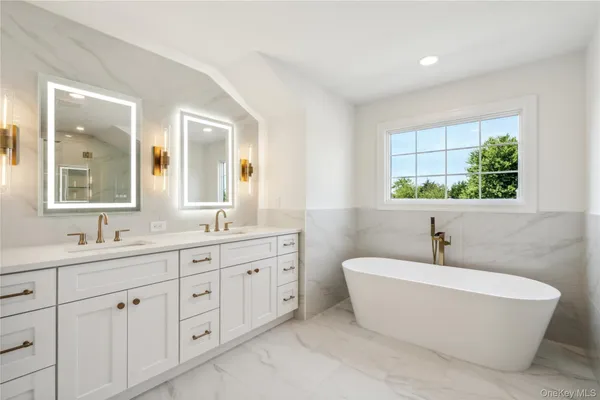 a bathroom with a double vanity sink a mirror and a bathtub