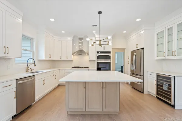 a large kitchen with stainless steel appliances kitchen island granite countertop a refrigerator a oven a sink and a granite counter tops