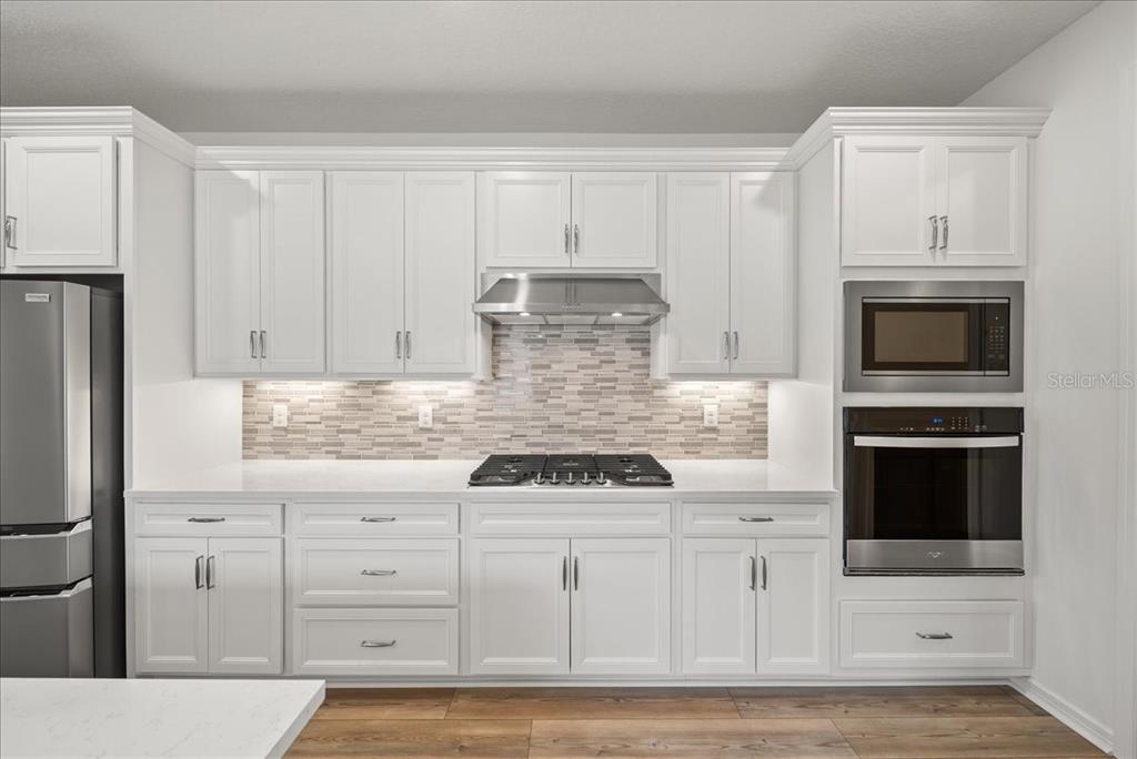 9434 Ballaster Pointe Loop Palmetto, FL 34221 - Photo 13 of 66 a kitchen with white cabinets and appliances